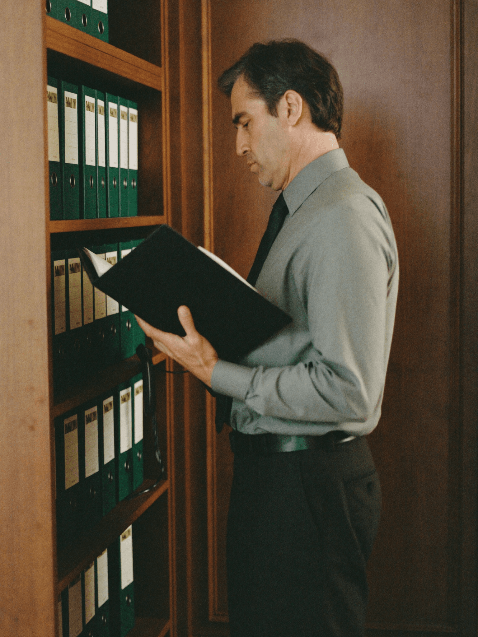 A founding partner reviewing case files in a boutique law firm office