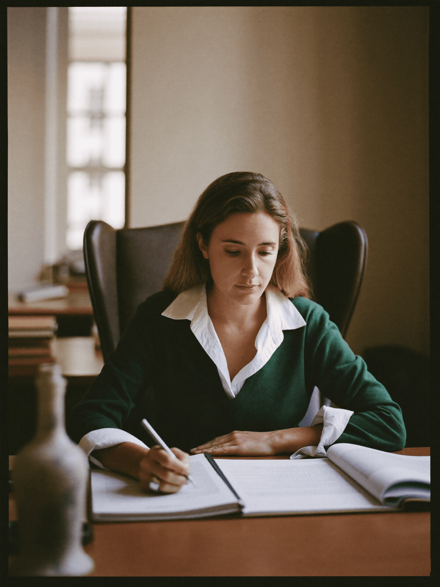 A managing partner reviewing case files at her desk